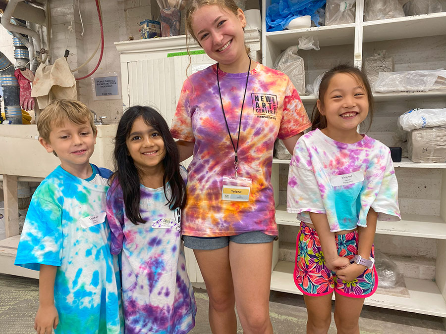 Students in vibrant tie-dye shirts pose happily, showcasing their involvement in a scholarship sponsorship program.